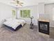 A well-lit bedroom showcases a fireplace and a large window with views of a lush green yard at 12912 Grant Cir # A, Thornton, CO 80241