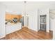Open-concept dining area with hardwood floors, modern chandelier, and view of the staircase and kitchen at 12912 Grant Cir # A, Thornton, CO 80241