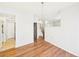 Open-concept dining room with wood floors, a chandelier, and views of the stairs and kitchen at 12912 Grant Cir # A, Thornton, CO 80241