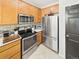 Kitchen featuring stainless steel appliances, wood cabinets, and bright countertop at 12912 Grant Cir # A, Thornton, CO 80241