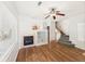 Spacious living room with hardwood floors, fireplace, ceiling fan, and staircase at 12912 Grant Cir # A, Thornton, CO 80241