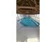 Indoor pool with wooden ceiling beams and wall to wall windows at 4212 W Pondview Dr, Littleton, CO 80123