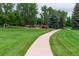 Scenic view of the community park featuring walking paths, lush green space and mature trees, ideal for outdoor activities and recreation at 2777 S Sedalia St, Aurora, CO 80013