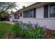 Charming home exterior with a well-maintained lawn and a garden with purple flowers in the front yard at 4425 E Harvard Ave, Denver, CO 80222