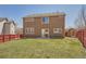 A two-story back exterior with siding and a door that opens onto a lawn with shed and a red fence at 20229 E Red Fox Ln, Centennial, CO 80015