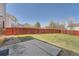 A spacious backyard with a well-maintained lawn and a red fence, perfect for outdoor activities and privacy at 20229 E Red Fox Ln, Centennial, CO 80015
