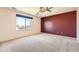 Bright bedroom with large window offering outside views, neutral carpet, and an elegant ceiling fan at 20229 E Red Fox Ln, Centennial, CO 80015