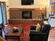 Cozy living room featuring a brick fireplace, hardwood floors, and comfortable seating at 14963 E Adriatic Pl, Aurora, CO 80014