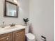 Well-lit half bathroom features a sink, toilet, and classic decorative accents at 6768 Vivian St, Arvada, CO 80004
