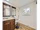 Bathroom with wood cabinets, double sinks, and a spacious vanity area with natural light at 6768 Vivian St, Arvada, CO 80004