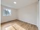 Sunny bedroom with hardwood floors, large window, and a clean, minimalist design at 6768 Vivian St, Arvada, CO 80004