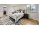 Relaxing bedroom features a cozy bed, bedside tables, and windows with a view at 6768 Vivian St, Arvada, CO 80004