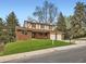 Charming two-story home featuring a brick facade, well-manicured lawn, and an attached two-car garage at 6768 Vivian St, Arvada, CO 80004