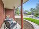 Inviting front porch featuring chairs, brick facade, and view of the well-maintained neighborhood at 6768 Vivian St, Arvada, CO 80004