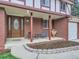 Charming front porch with brick accents, dark wood door, and neat landscaping at 6768 Vivian St, Arvada, CO 80004