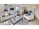 Bright living room features modern furniture, light hardwood floors, and an open view to the dining area at 6768 Vivian St, Arvada, CO 80004
