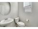 Clean, well-lit powder room with a pedestal sink, round mirror, and a window with blinds at 7686 Grady Cir, Castle Rock, CO 80108