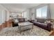 Inviting living room with hardwood floors, sofas, and a neutral rug, seamlessly flowing into the kitchen at 7686 Grady Cir, Castle Rock, CO 80108