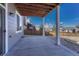 Covered outdoor patio with a concrete floor, supported by white pillars, and adjacent to a well-kept backyard at 7686 Grady Cir, Castle Rock, CO 80108