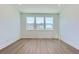Bright bedroom featuring three large windows providing natural light and wood-look flooring at 20578 E 63Rd Ave, Aurora, CO 80019