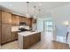 Bright kitchen features an island with quartz countertops, wood cabinets, stainless appliances and pendant lighting at 20578 E 63Rd Ave, Aurora, CO 80019