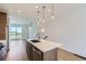 Bright kitchen features an island with quartz countertops, stainless appliances, pendant lighting, and an open floorplan at 20578 E 63Rd Ave, Aurora, CO 80019