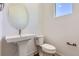 Powder room with a pedestal sink, a modern mirror, and a toilet with chrome accents at 20578 E 63Rd Ave, Aurora, CO 80019