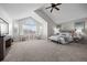 Bright main bedroom with vaulted ceilings, seating area, ceiling fan, and a large window at 7067 Gray Fox Ct, Highlands Ranch, CO 80130