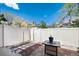 A quaint outdoor space, with a small table on a bed of mulch bordered by rocks and a white fence at 9713 W Chatfield Ave # F, Littleton, CO 80128