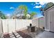 Private patio area with a modern fire pit and white fence, perfect for relaxation and entertaining at 9713 W Chatfield Ave # F, Littleton, CO 80128