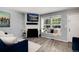 Inviting living room features a fireplace, mounted TV, and a sunlit window seat with plush pillows at 9713 W Chatfield Ave # F, Littleton, CO 80128