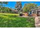 Well-manicured backyard with a patio, grill, and lush lawn, creating an inviting space for outdoor activities and gatherings at 13610 W Dakota Pl, Lakewood, CO 80228