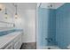 Bathroom featuring retro-style blue tile, hanging globe lights, and a large vanity at 13610 W Dakota Pl, Lakewood, CO 80228