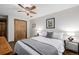 Comfortable bedroom featuring a queen-sized bed, wood flooring, and soft lighting, creating a serene and inviting retreat at 13610 W Dakota Pl, Lakewood, CO 80228