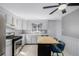 Bright kitchen with stainless steel appliances, white cabinets, eat-in island, and modern fixtures at 13610 W Dakota Pl, Lakewood, CO 80228