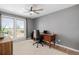 Well-lit home office with a large window, a ceiling fan, and a wood desk create a productive and comfortable workspace at 13610 W Dakota Pl, Lakewood, CO 80228