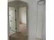 Hallway with arched doorway, patterned tile, and neutral paint leads to rooms with wood-look floors at 3243 Albion St, Denver, CO 80207