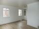 Bright living room with wood-look flooring, built-in shelving, and two windows for ample natural light at 3243 Albion St, Denver, CO 80207