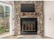 Close up of stone fireplace with mounted television above, featuring sliding glass doors for natural light at 1621 S Idalia Cir # D, Aurora, CO 80017