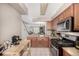 Compact kitchen showcases stainless steel appliances, wood cabinetry, and a seamless view into the living area at 1621 S Idalia Cir # D, Aurora, CO 80017