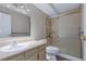 Bathroom featuring a shower with accessible features, a tile surround, sink, and mirror at 13606 E Bates Ave # 102, Aurora, CO 80014