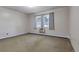 Bright bedroom features neutral walls, carpet flooring, and a window with gray curtains at 13606 E Bates Ave # 102, Aurora, CO 80014