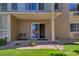 Condo entrance featuring a sliding door, small porch area, and well-maintained landscaping at 13606 E Bates Ave # 102, Aurora, CO 80014