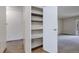 Hallway features shelving unit with an open door, showing an entry into a carpeted room at 13606 E Bates Ave # 102, Aurora, CO 80014
