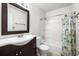 Bright bathroom featuring a tub with shower, a modern vanity, and a decorative cactus-themed shower curtain at 1712 S Kline Way, Lakewood, CO 80232