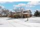 Charming multi-level home with a manicured lawn and a brick facade, set against a backdrop of mature trees at 1712 S Kline Way, Lakewood, CO 80232