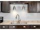 Stylish kitchen featuring modern dark cabinets, stainless steel sink, and a white subway tile backsplash at 1712 S Kline Way, Lakewood, CO 80232