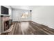 Bright living room featuring hardwood floors, a cozy fireplace, and large windows that let in plenty of natural light at 1712 S Kline Way, Lakewood, CO 80232