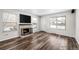 Inviting living room with hardwood floors, brick fireplace, and a large window that fills the space with natural light at 1712 S Kline Way, Lakewood, CO 80232