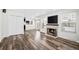 Bright living room featuring dark wood flooring, a cozy fireplace, and large windows that let in plenty of natural light at 1712 S Kline Way, Lakewood, CO 80232